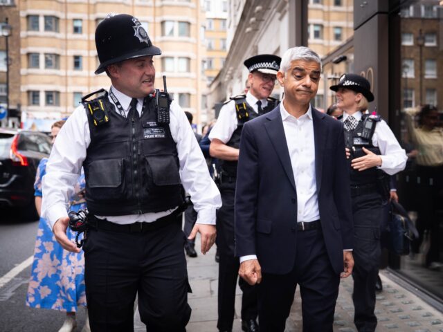 Mayor of London Sir Sadiq Khan speaks with police officers during a walkabout in the West