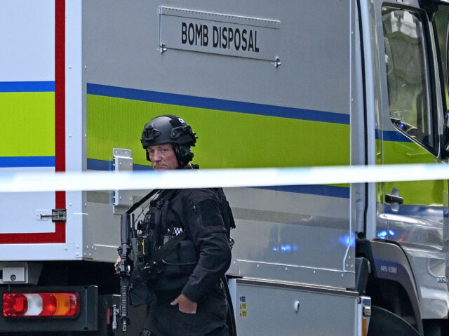 An Armed Police officer walks past a bomb disposal van outside Heaton Park Hebrew Congrega