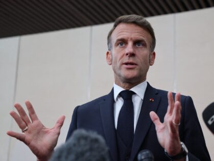 France's President Emmanuel Macron gestures as he speaks to the press at the end of the 7t