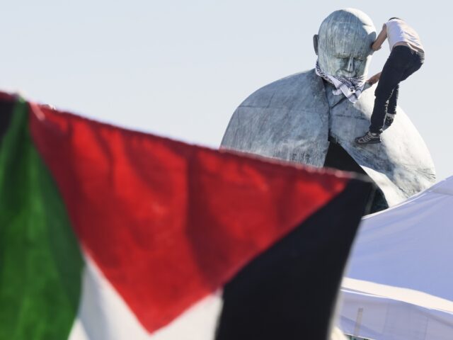 ROME, ITALY - OCTOBER 3:A boy climbs onto the statue of Saint Pope John Paul II in Piazza