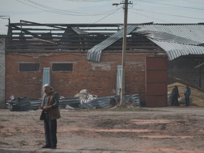 KHARKIV OBLAST, UKRAINE - OCTOBER 3: Men stand at a farm building hit by a Russian drone s