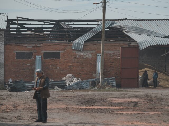 KHARKIV OBLAST, UKRAINE - OCTOBER 3: Men stand at a farm building hit by a Russian drone s