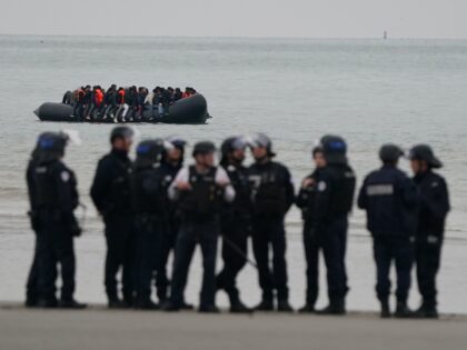 French authorities watch as a small boat carrying people thought to be migrants leaves Gra