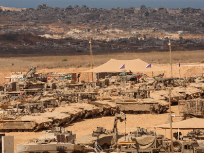 Israeli soldiers conduct maintenance work on their armoured vehicles at a position along t