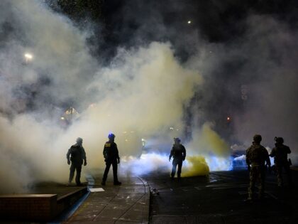 PORTLAND, OREGON - OCTOBER 18: Federal agents walk through tear gas at the U.S. Immigratio