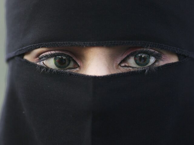 BLACKBURN, UNITED KINGDOM - OCTOBER 14: A Muslim woman wearing a niqab veil protests outsi