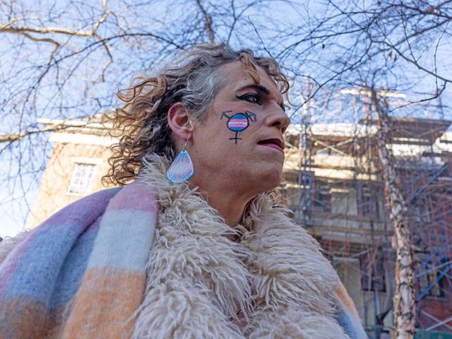 Members of the LBGTQ+ community and allies protest the removal of the word transgender fro