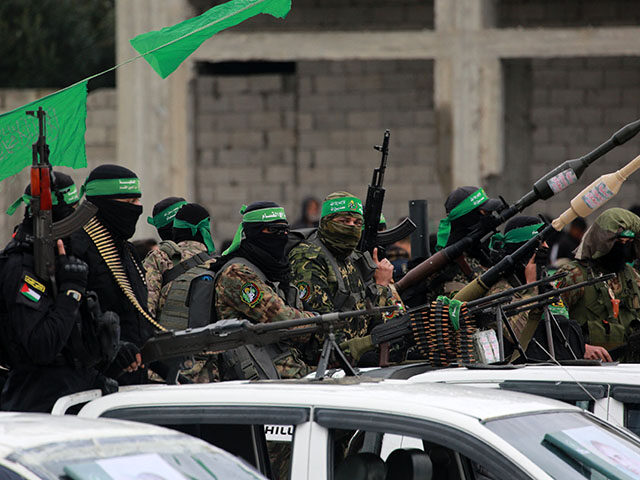GettyImages2200480685 Palestinian Hamas fighters carry their guns in Nuseirat in the central Gaza Strip, as prep