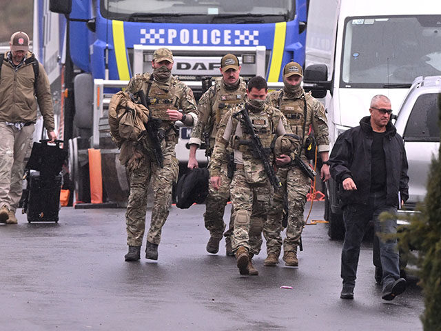 Heavily armed police gather at a police staging point during the search for a fugitive lin