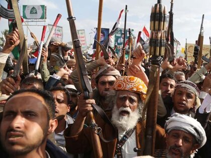 Yemenis brandish weapons, flags of Yemen and Palestine, and anti-US and Israel emblems and