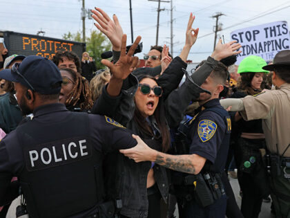 Demonstrators interact with police in the street outside of the "Free Speech Zone" near th
