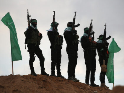 Palestinian Hamas militants gather at the site of the handing over of the bodies of four I