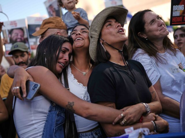 People react as they gather to watch a live broadcast of Israeli hostages released from Ga