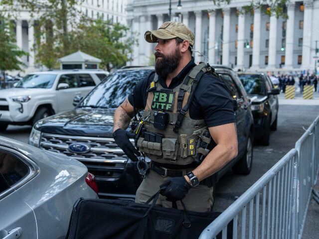 ICE operation in NYC A federal agent retrieves something from a vehicle outside of 26 Federal Plaza on October