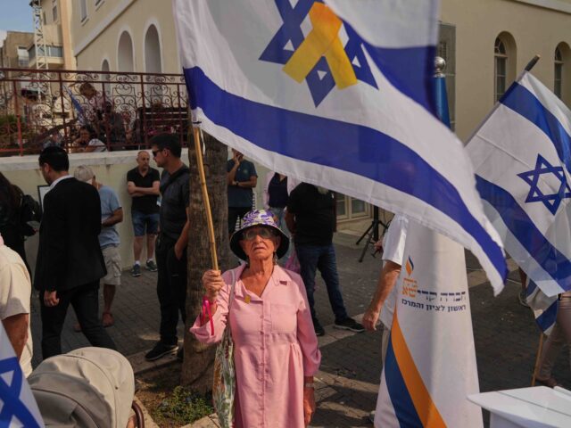 Mourners gather next to the van carrying the coffin of slain hostage Inbar Haiman during h