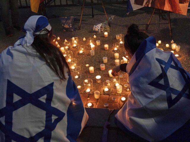 FILE - People gather to light candles in a makeshift memorial to honor Yaron Lischinsky an