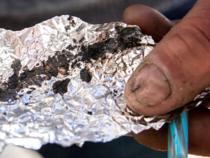 Roger Boyd, 35, holds a piece of foil containing Fentanyl while spending time on McAlliste