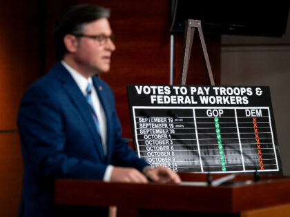 US House Speaker Mike Johnson, a Republican from Louisiana, speaks in front of a sign read