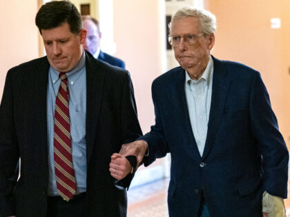 U.S. Senate Minority Leader Mitch McConnell (R-KY) is assisted by staff as he goes to the