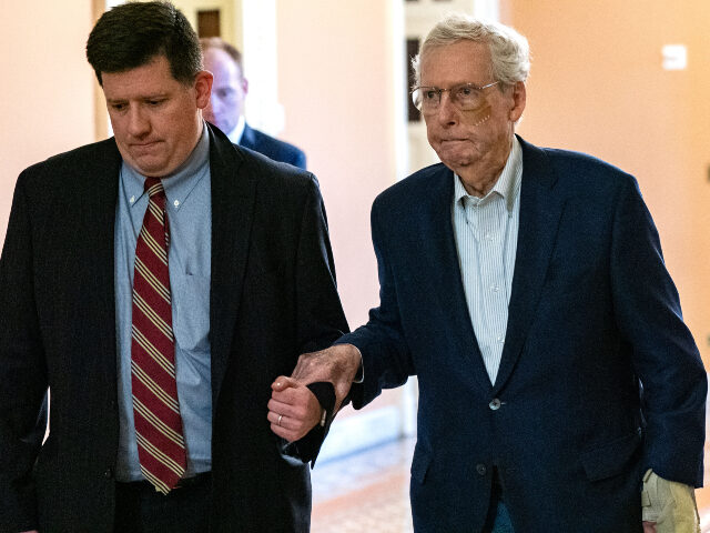 Mitch McConnell U.S. Senate Minority Leader Mitch McConnell (R-KY) is assisted by staff as he goes to the