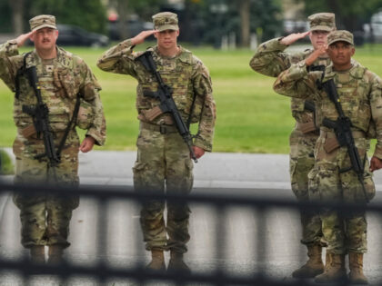 National Guard soldiers salute as President Donald Trump's motorcade drives by, Satur