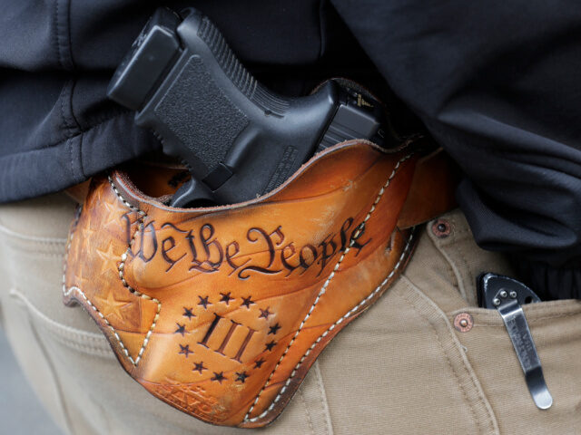 Open Carry Gun in Holster An attendee at a gun rights rally open-carries his gun in a holster that reads "We th