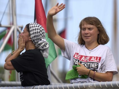 Swedish climate activist Greta Thunberg waves from a boat taking part in a civilian flotil