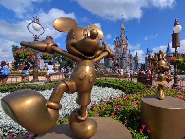 Two Disney World visitors ORLANDO, FL - APRIL 3: Statues of Mickey Mouse and Minnie Mouse stand in a garden in front