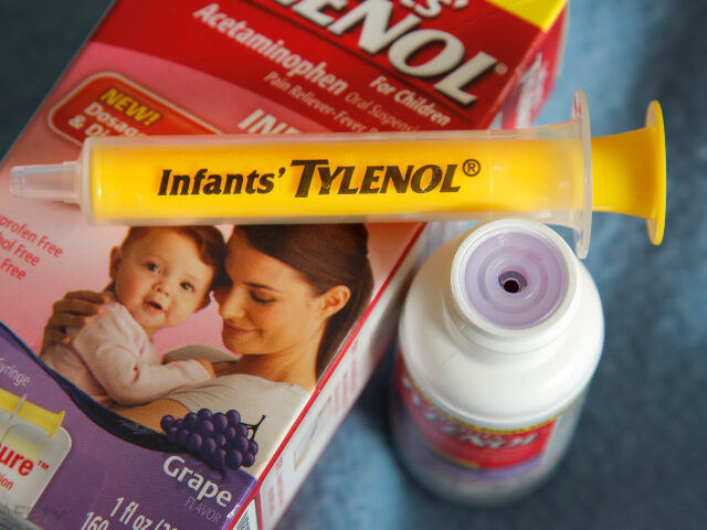 A container of grape-flavored Infants' Tylenol liquid medicine with the enclosed syri