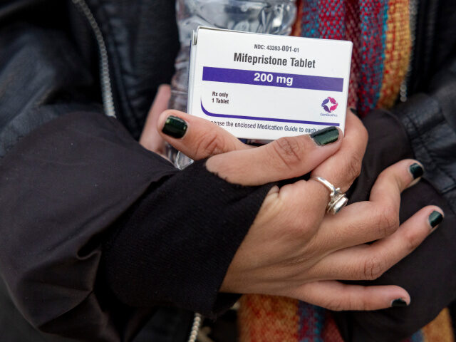 Woman Holds Mifepristonw Pills An abortion- rights activist holds a box of mifepristone pills as demonstrators from both