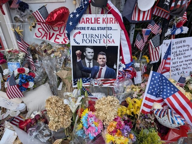 LEMONT, ILLINOIS, UNITED STATES - SEPTEMBER 21: A pile of flowers, candles, and photos pla