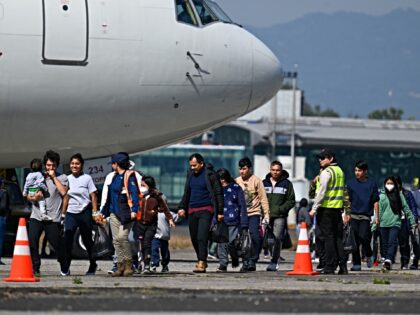Guatemalan migrants deported from the United States walk on the tarmac after landing at th