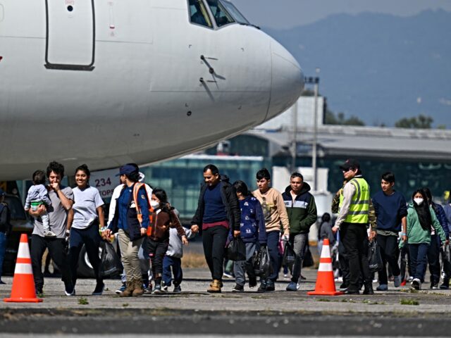 Guatemalan migrants deported from the United States walk on the tarmac after landing at th
