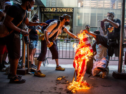 NEW YORK, NY - JULY 4: A group of protesters burn an American flag in front of the Trump T