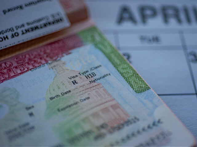 H1B visa (for specialty workers) stamp in passport, blurred april calendar on background.