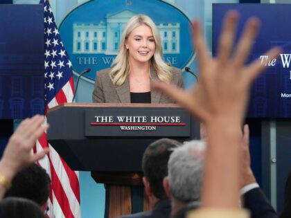 Reporters raise their hands to ask a questions during a press briefing with White House pr
