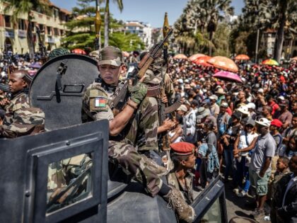 TOPSHOT - Members of Madagascar's CAPSAT army unit patrol on an armoured vehicle as r