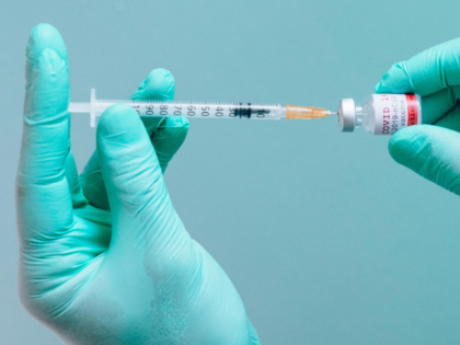 A Person Holding a Syringe and a Vial