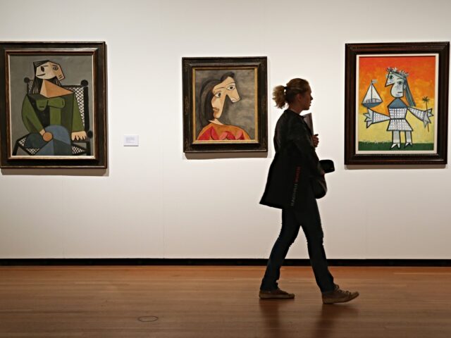 picasso BERLIN, GERMANY - SEPTEMBER 08: A visitor walks past paintings by Pablo Picasso during a p