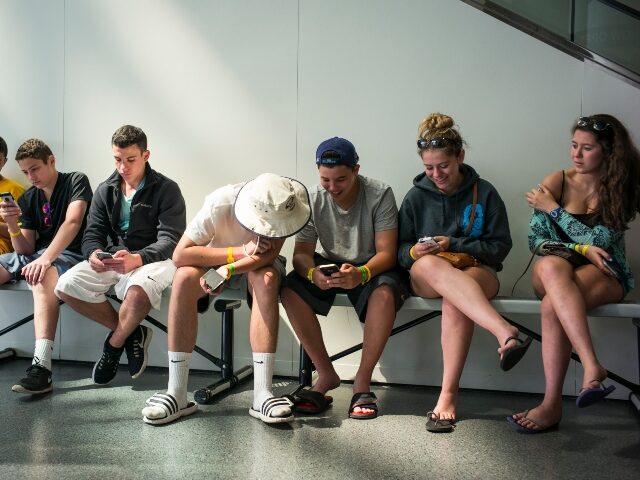 teens stare at cell phones