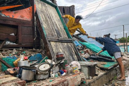 A family salvages belongings from the rubble of their home after it collapsed during Hurri