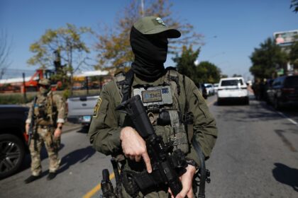 A masked US immigration agent patrols Chicago, where President Donald Trump is also planni