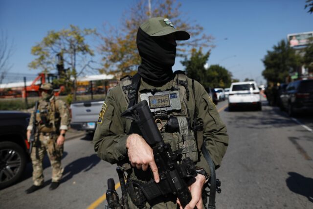 A masked US immigration agent patrols Chicago, where President Donald Trump is also planni