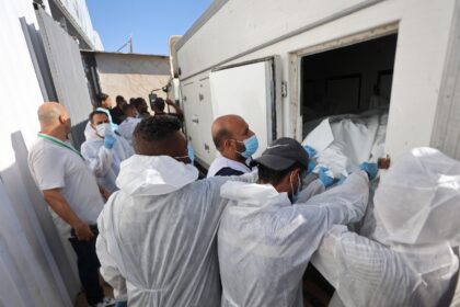 Morgue workers unload the bodies of Palestinians that had been in Israeli custody, after t