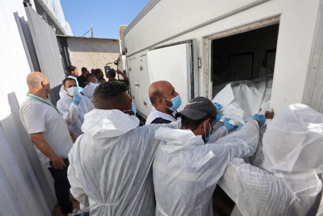 Morgue workers unload the bodies of Palestinians that had been in Israeli custody, after t