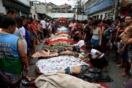 People line up bodies on Sao Lucas Square of the Vila Cruzeiro favela at the Penha complex