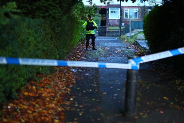 Police officers outside a house believed to that of the attacker
