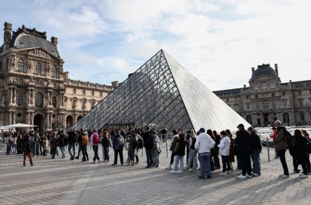 Visitors queue to get in to the Louvre, days after it was robbed in Paris