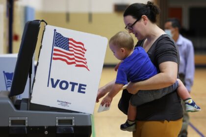 A voter casts her ballot with her child in in Virginia, one of two states holding gubernat