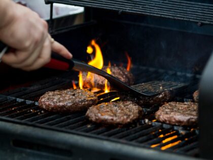 person grilling hamburger patties
